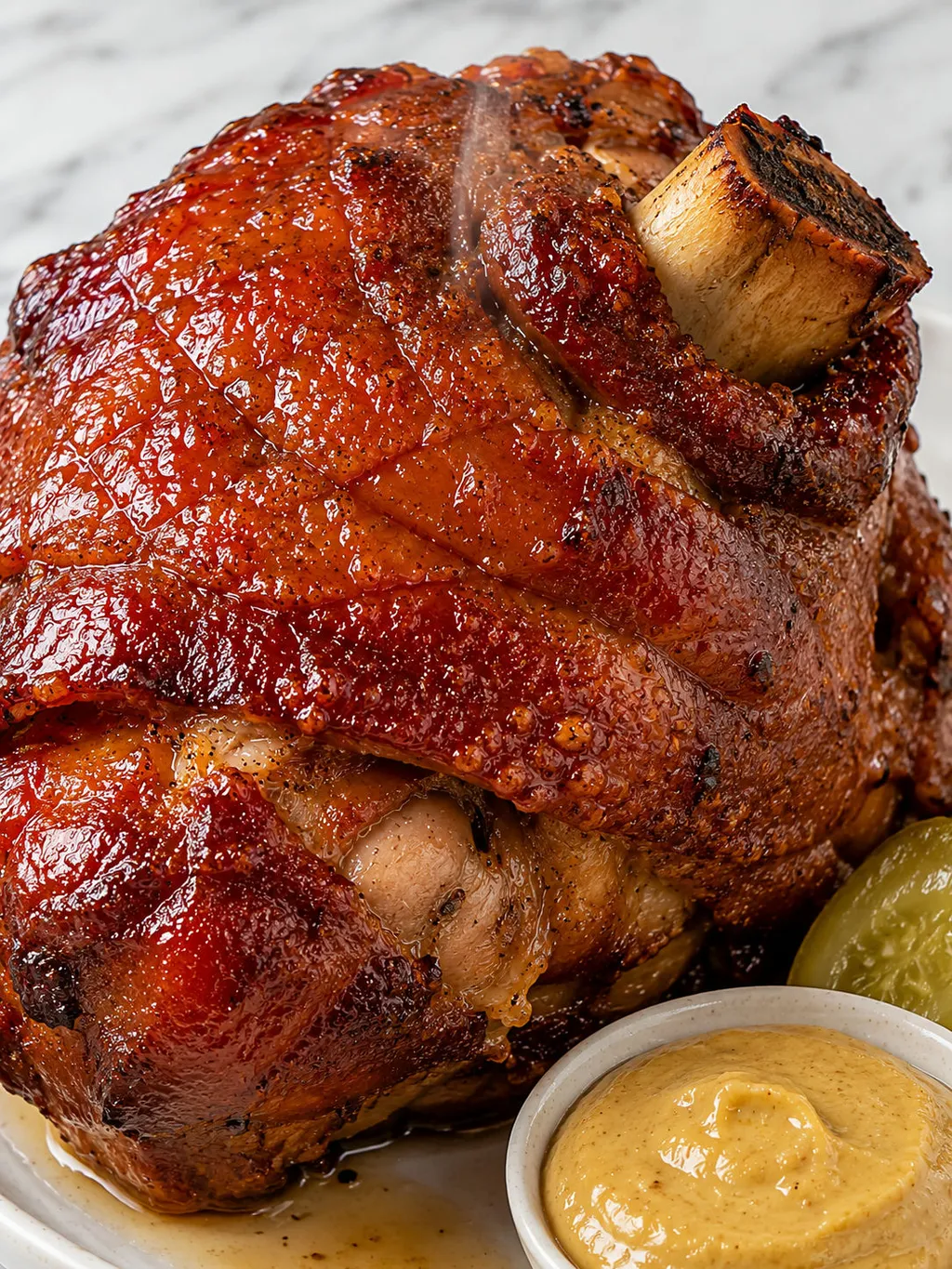 Close-up of roasted pork knuckle with cracked crispy skin and glossy beer glaze