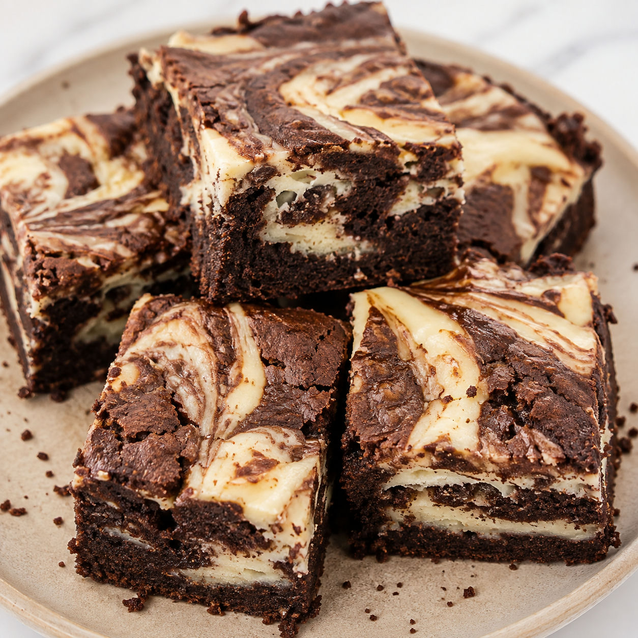 Keto brownie sernikowe z jasnymi smugami sera na talerzu