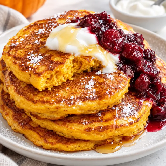 Placuszki z dynią z jogurtem i miodem na jasnym talerzu