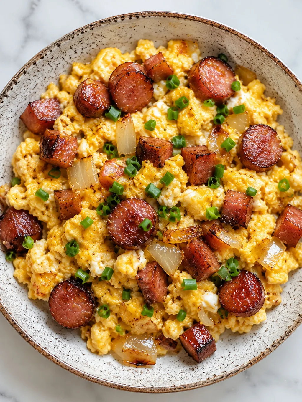 Top-down plate of Polish jajecznica scrambled eggs with kielbasa and chives