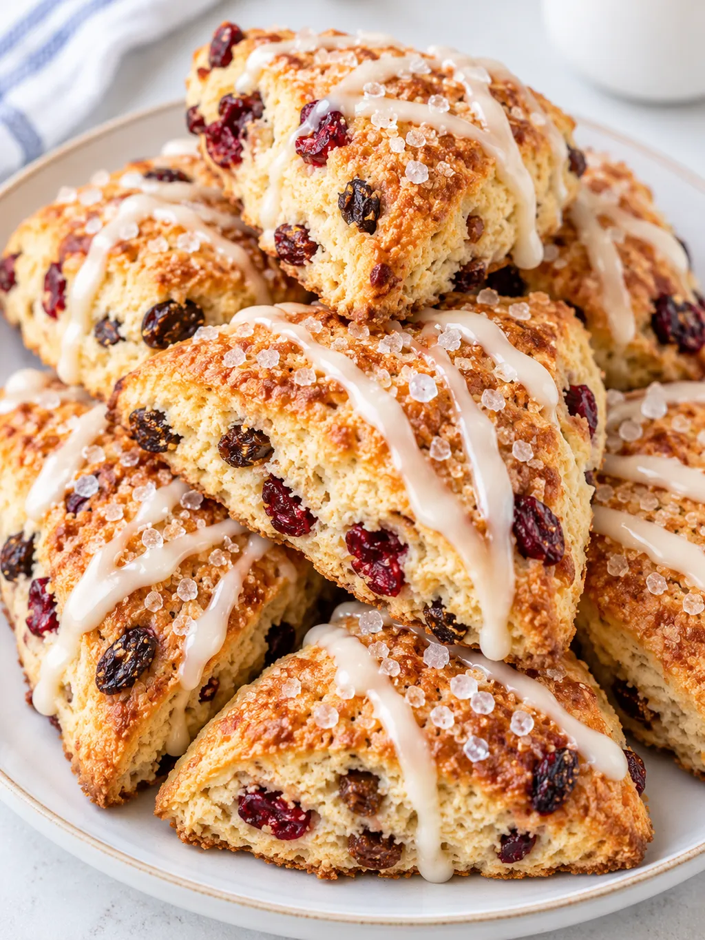 Rumiane scones z rodzynkami i żurawiną na jasnym talerzu